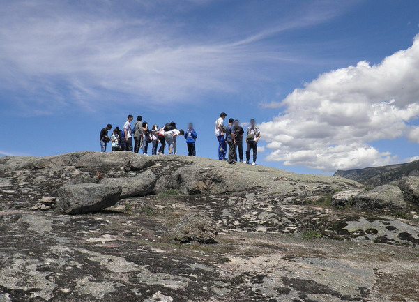 Un grupo de alumnos sobre una zona de roca divisando el paisaje
