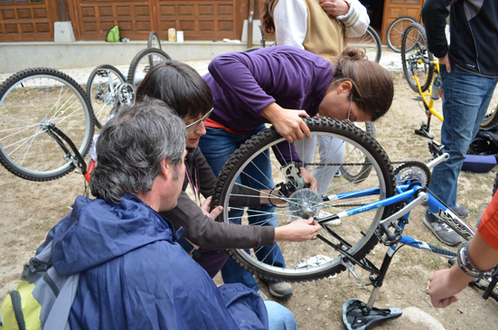 Los participantes en las VI jornadas realizando un taller de reparación de bicicletas con Irene del Pozo