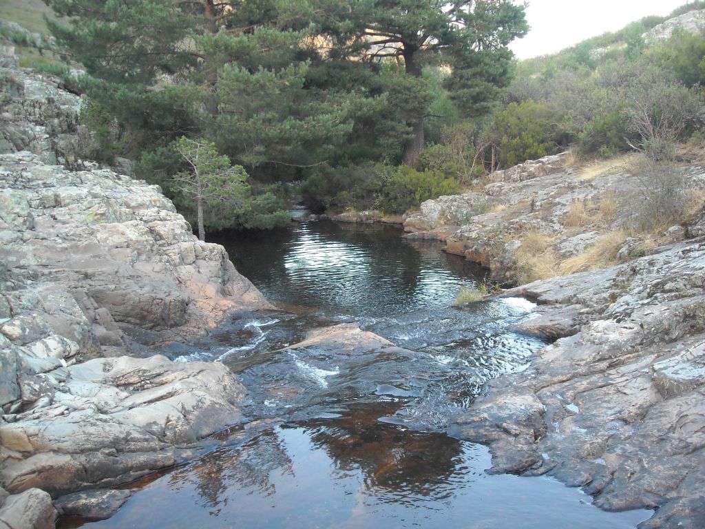 El agua discurre sobre roca madre en la reserva natural fluvial Río Pelagallinas