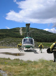 Fotografia de miembros de una brigada Brief B junto a su helicoptero de transporte