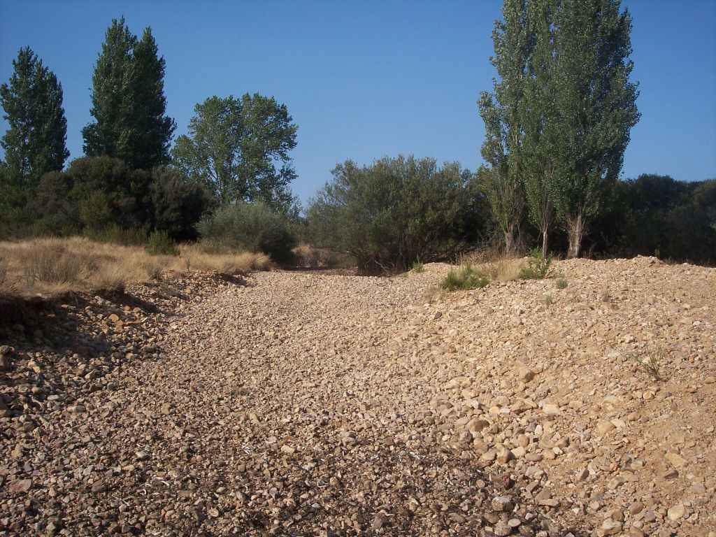 La reserva natural fluvial río Gargáligas en época de estiaje muestra su lecho de gravas y cantos rodados
