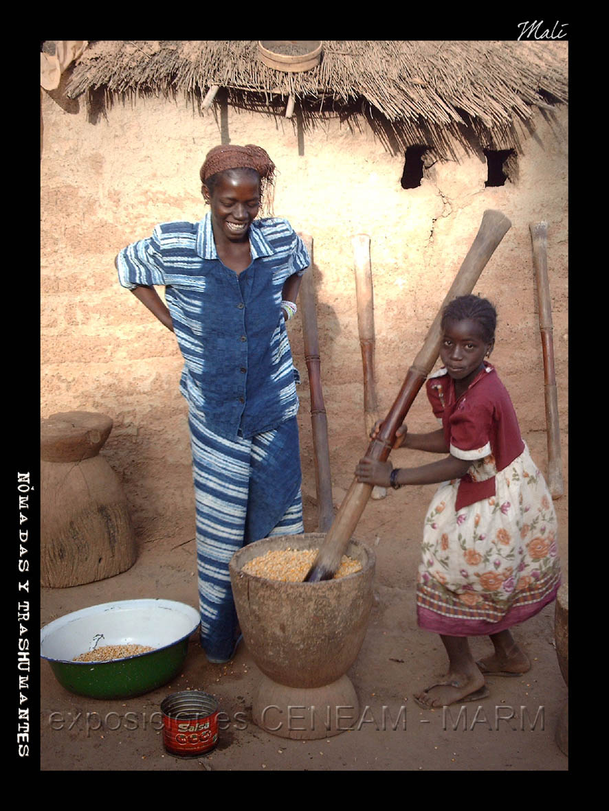 Madre e hijo machacando grano en Mali